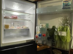 宿にある冷蔵庫。葉物野菜を長持ちさせるため、ドアポケット部分に野菜を立てている。
